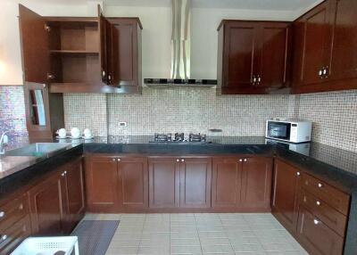 Modern kitchen with dark wood cabinets and built-in appliances