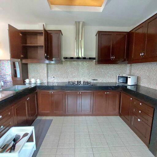 Modern kitchen with dark wood cabinets and built-in appliances