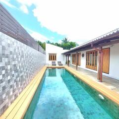 Outdoor pool area with wooden deck and lounge chairs