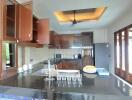 Modern kitchen with open cabinets, black granite countertops, and glassware