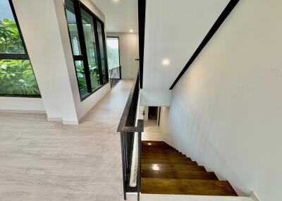 Modern stairway with large windows and greenery view