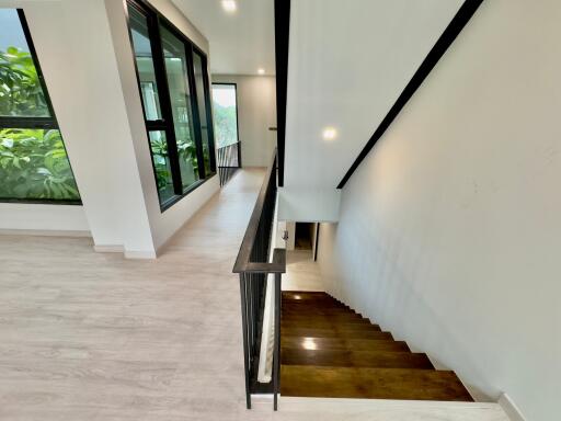 Modern stairway with large windows and greenery view