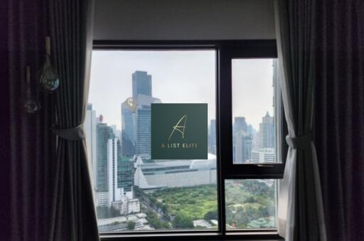 View of cityscape with tall buildings from a window with curtains