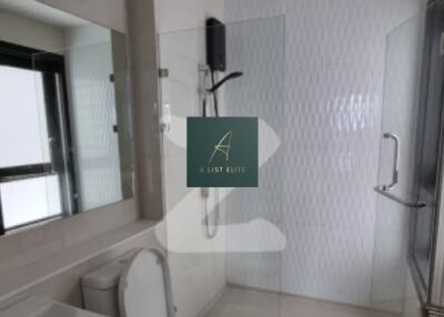 Modern bathroom with a glass shower enclosure, white fixtures, and a large mirror