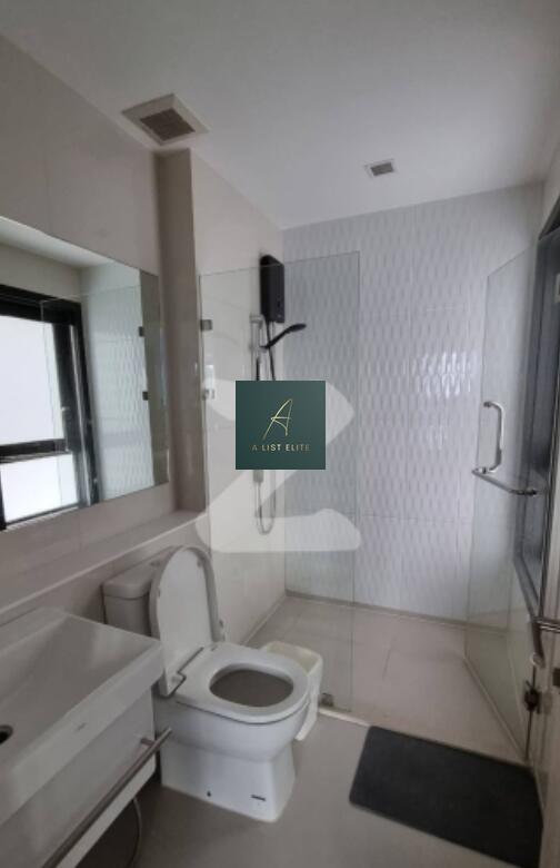 Modern bathroom with a glass shower enclosure, white fixtures, and a large mirror