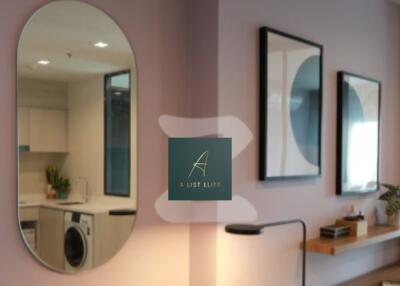 Modern living room with mirror, wall art, and a glimpse of the adjacent kitchen