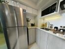 Modern kitchen with stainless steel refrigerator and built-in microwave