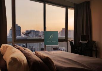 bedroom with city view during sunset