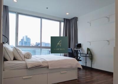 Modern bedroom with large windows and city view