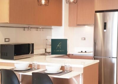 Modern kitchen with wooden cabinets, stainless steel appliances, and a breakfast bar