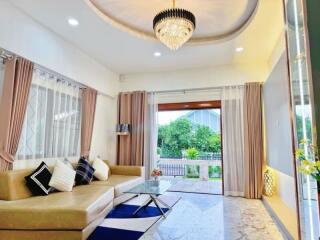 Modern living room with chandelier and large windows