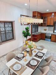 Dining area with a well-set table and kitchen in the background