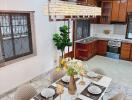 Dining area with a well-set table and kitchen in the background