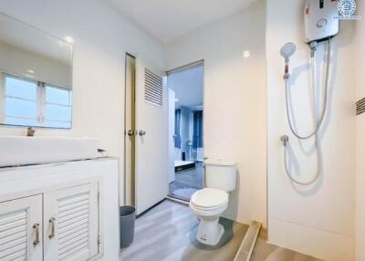 Modern white bathroom with sink, toilet, and water heater