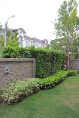 Well-maintained garden area with lush greenery and a view of neighboring townhouses