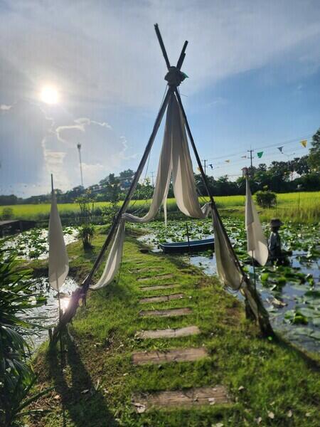 Peaceful outdoor area with walkway over water surrounded by greenery