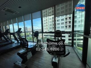 Fitness center with exercise equipment and large windows