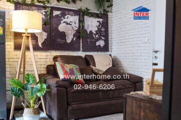 Cozy living room with a leather sofa, world map wall art, and floor lamp