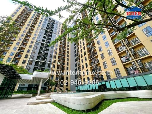 Exterior view of a multi-story residential building with balconies and ground-level amenities