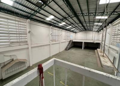 Interior view of a large industrial warehouse with mezzanine and stairs