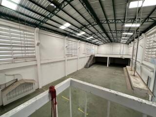 Interior view of a large industrial warehouse with mezzanine and stairs