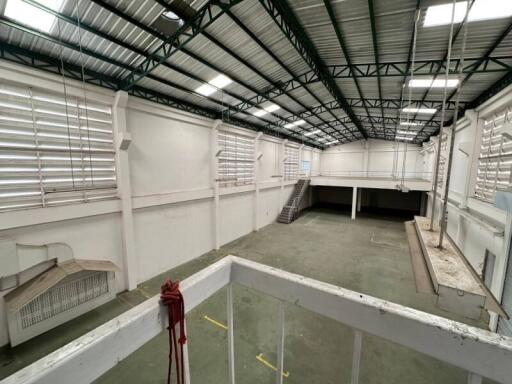 Interior view of a large industrial warehouse with mezzanine and stairs