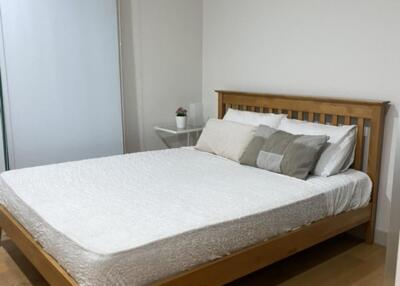 Bedroom with wooden bed frame and white bedding