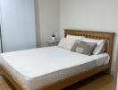 Bedroom with wooden bed frame and white bedding