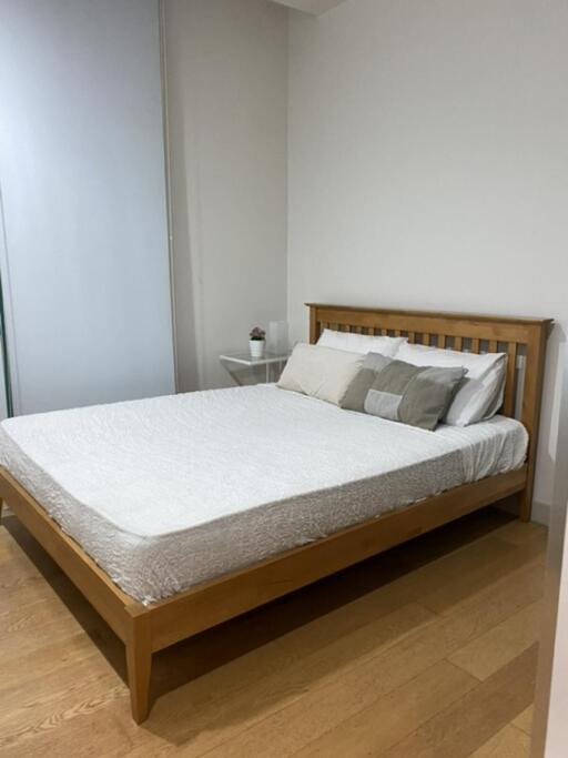 Bedroom with wooden bed frame and white bedding