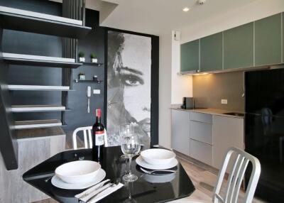 Modern kitchen area with dining table and staircase