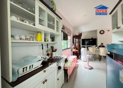 A kitchen view with dining area in the background