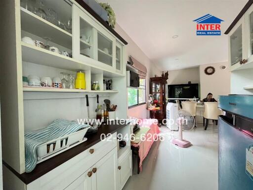 A kitchen view with dining area in the background