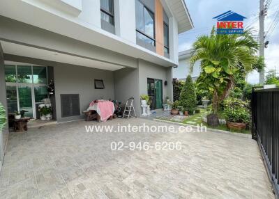 Outdoor view of a modern house with a driveway, garden, and greenery