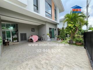 Outdoor view of a modern house with a driveway, garden, and greenery