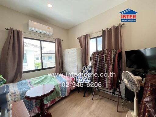 Bedroom with modern furnishings, air conditioner, and natural lighting