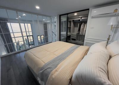 Modern bedroom with large windows and city view