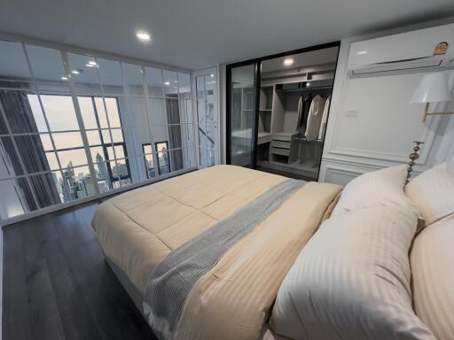 Modern bedroom with large windows and city view