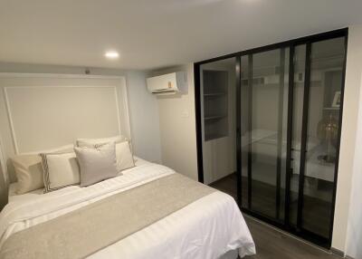 Modern bedroom with bed, pillows, and a wardrobe