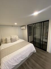 Modern bedroom with bed, pillows, and a wardrobe