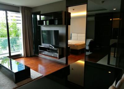 Modern living room with TV and a view into the bedroom