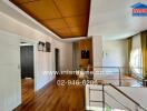 Spacious hallway with wooden flooring and ceiling, featuring access to multiple rooms and a staircase