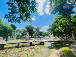 Scenic view of a landscaped garden with a small pond and a bridge