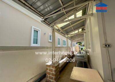 Covered outdoor walkway with side windows and utility area