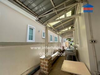 Covered outdoor walkway with side windows and utility area