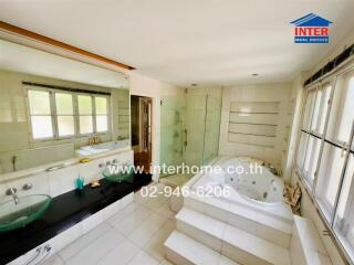 Spacious bathroom with bathtub and glass-enclosed shower