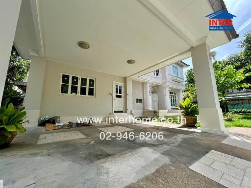 Covered garage area with a partial view of the house