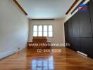 Empty bedroom with wooden floor and dark brown built-in wardrobe