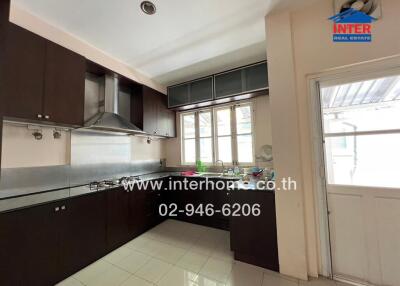 Modern kitchen with dark cabinets, stainless steel appliances, and a large window