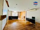 Spacious main living space with wooden flooring and ample natural light