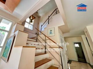 Bright staircase area with wooden steps and handrails